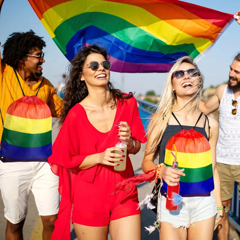People at a pride event with rainbow flags and accessories.